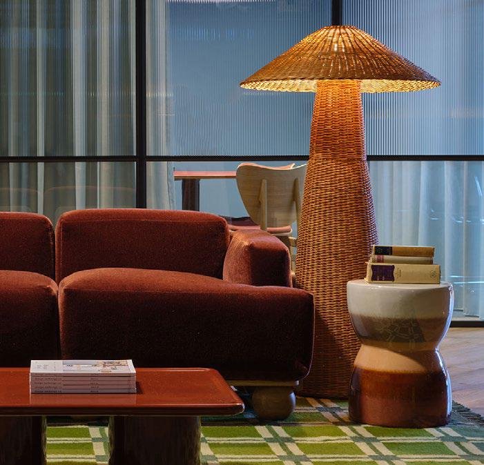 Raw District by Imtiaz Development - living area with rust-coloured sofa and floor-to-ceiling windows